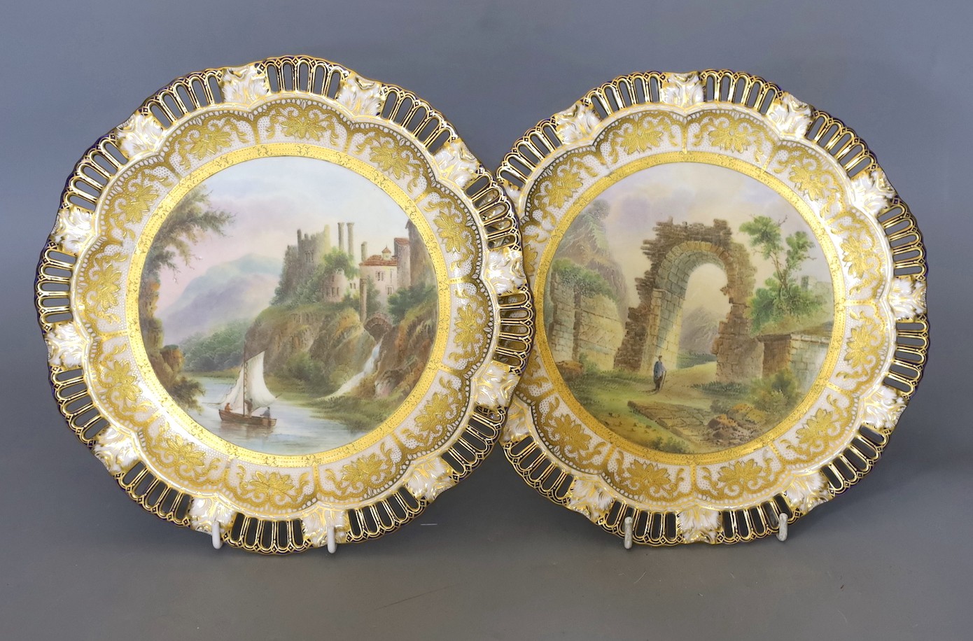 A pair of Coalport pierced border plates painted with named ruins scenes Chepstow Castle and Ruins of Checiliciam Gates mark Coalport AD 1750 in blue 23.5cm